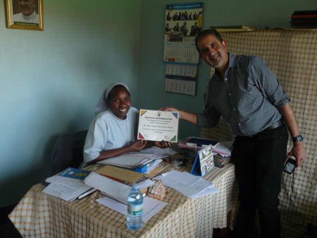 Dr.Arif handing over  a certificate to the head teacher SMG